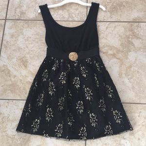 Black cocktail dress with gold designs.
